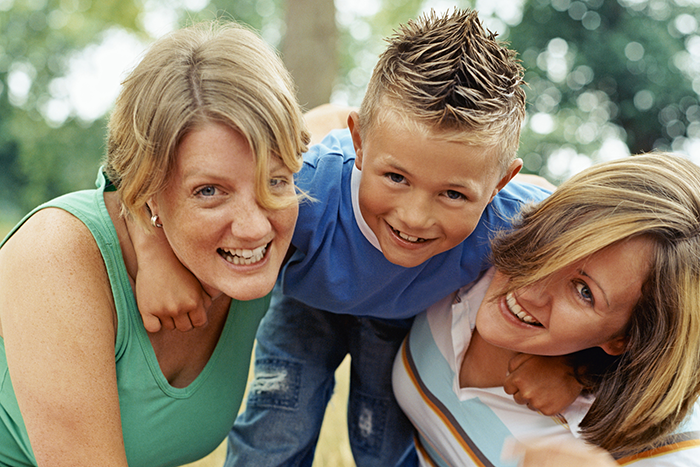 an image of two women and a young boy hugging
